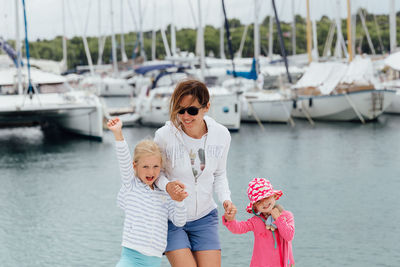 Mother with cute daughters standing at harbor