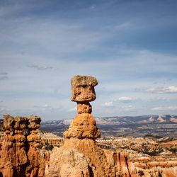 Rock formations in canyon against cloudy sky