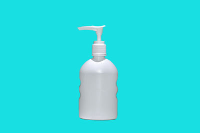 Close-up of white bottle against blue background