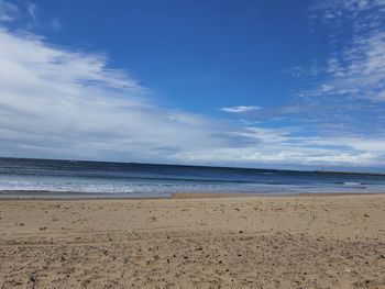 Scenic view of beach against blue sky