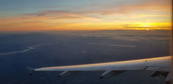 Airplane flying over sea during sunset