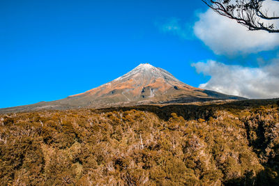 Scenic view of mountains against blue sky