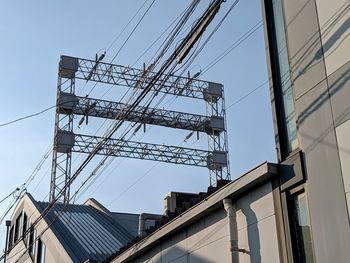 Low angle view of power supplies against sky