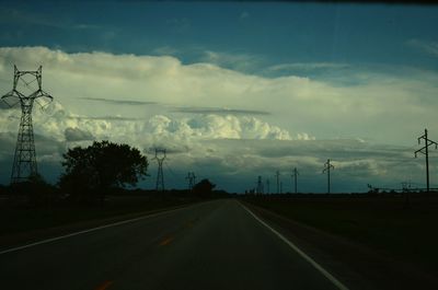 Country road against cloudy sky