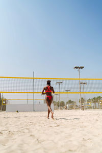 Woman with afro hair playing beach volleyball