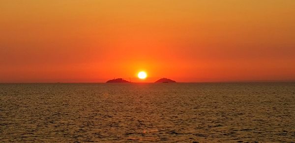 Scenic view of sea against romantic sky at sunset