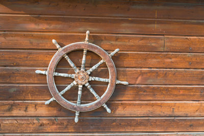 Close-up of helm on wooden wall