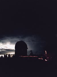 Silhouette people against illuminated sky at night