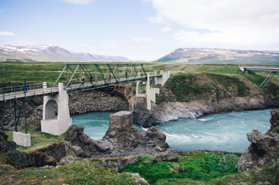 Arch bridge over river against sky