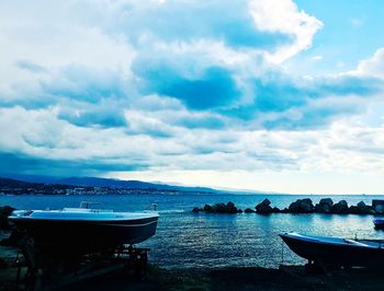 Boats moored on sea against sky