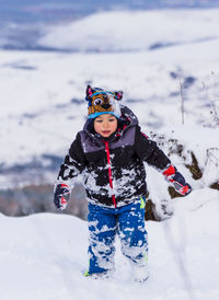 Boy standing on snowy land