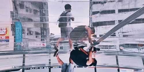 People working on glass building in city
