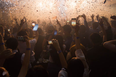 Group of people using mobile phones at music concert