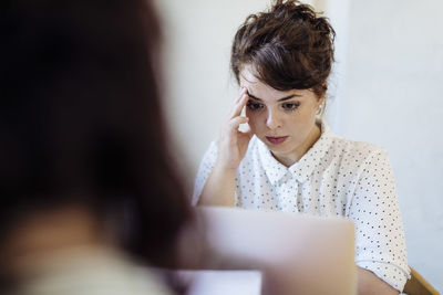 Concentrated businesswoman using laptop attentively