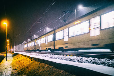 View of railroad tracks at night during winter