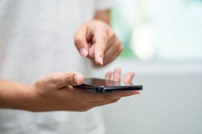 Midsection of man using mobile phone