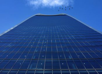 Low angle view of skyscrapers against blue sky