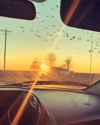 Road seen through car windshield during sunset