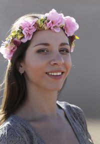 Close-up portrait of smiling young woman wearing flowers