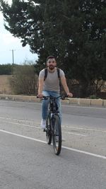 Portrait of man riding bicycle on road