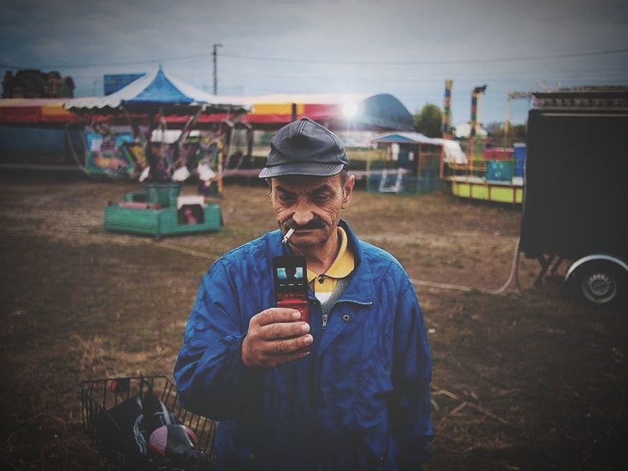 one person, real people, men, front view, waist up, occupation, portrait, lifestyles, standing, males, holding, cap, hat, land, field, glasses, food and drink, looking at camera, nature, mature men, outdoors