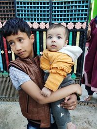 Close-up of boy carrying baby girl