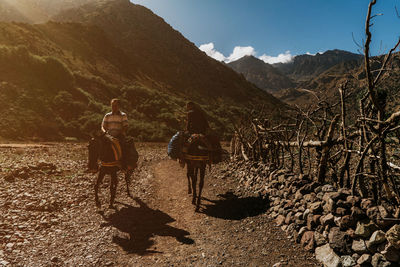 Rear view of people on mountain against sky