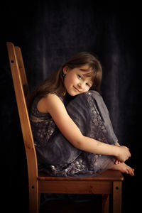 Full length of girl sitting on chair