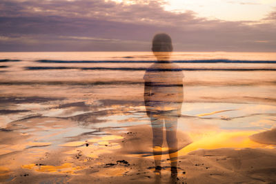 Full length of girl standing at beach during sunset