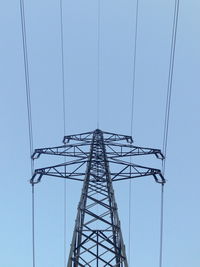 Low angle view of electricity pylon against clear sky