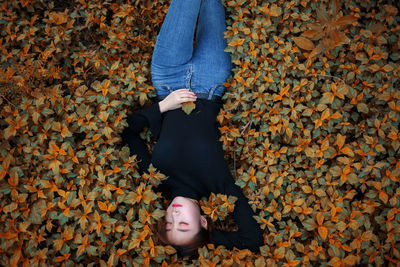 High angle view of woman lying on plants during autumn