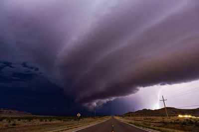 Storm clouds over road during sunset