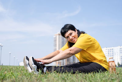 Portrait of smiling young man on field against sky