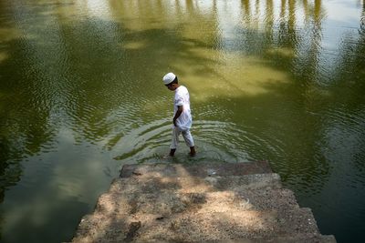 Rear view of man fishing in lake