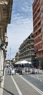 City street by buildings against sky