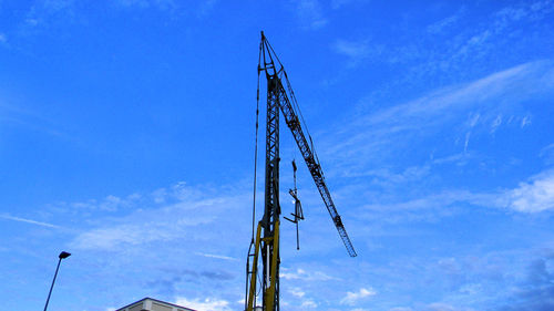 Low angle view of crane against blue sky