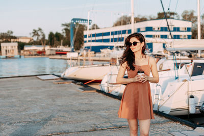 Woman standing by boat in water