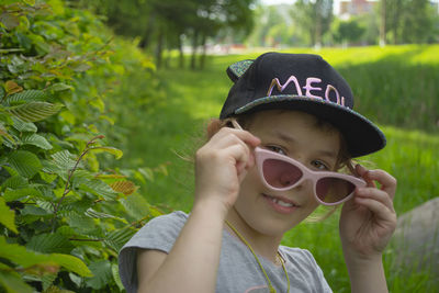 Portrait of boy wearing sunglasses against plants