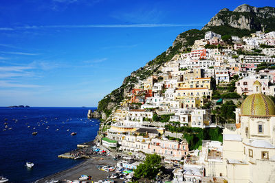 High angle view of townscape by sea against sky