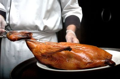 Close-up of man carving roast goose 