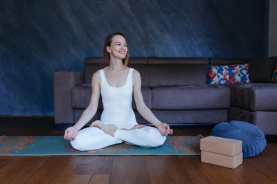 Young woman sitting on sofa at home