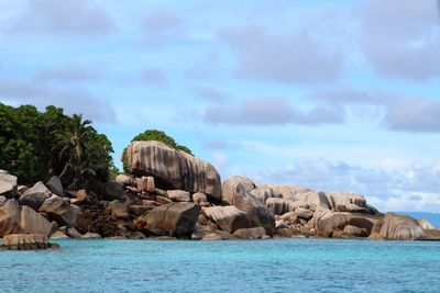 Panoramic shot of rocks by sea against sky