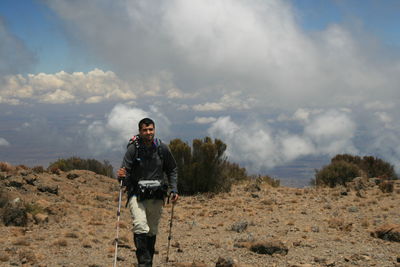 Portrait of man standing on landscape against sky