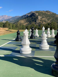 Full length of people relaxing on mountain against sky