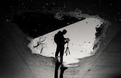 High angle view of man reflecting on puddle