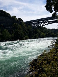 Scenic view of river against cloudy sky