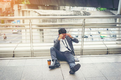 High angle view of tensed businessman while sitting on elevated walkway