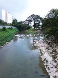 Scenic view of lake against sky in city