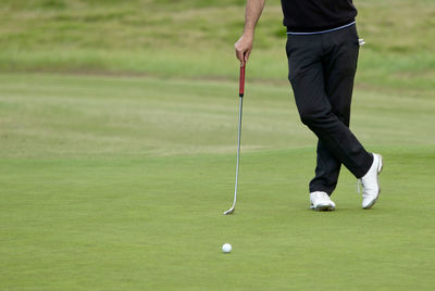 Low section of person standing on golf ball