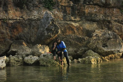 Portrait of mother and daughter in lake against rock formations